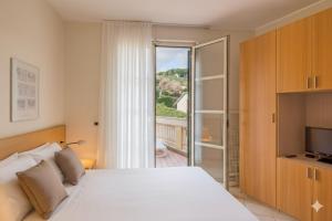 a bedroom with a white bed and a sliding glass door at Residenza al Porto in Spotorno +126 photos