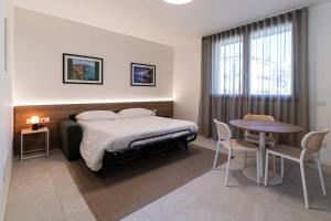 a bedroom with a bed and a table and chairs at Appartamenti "Primula - Fiordaliso" - Cascina Da Rosa in Capiago Intimiano