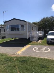 a mobile home is parked in a parking lot at Dog Friendly 6 Berth Caravan With Decking Close To Pakefield Beach Ref 68106Cr in Pakefield