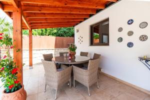 a dining room with a table and chairs on a patio at 4 Bedroom Villa With Private Pool in Maroni