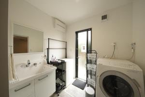 a bathroom with a washing machine and a sink at Awaji Nature Retreat in Awaji