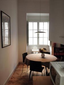 ein Esszimmer mit Tisch und Stühlen und einem Fenster in der Unterkunft Casa da Catedral in Porto