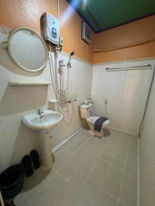 a bathroom with a sink and a mirror and a toilet at Le Jardin 2 Organique Guesthouse Vang Vieng in Vang Vieng