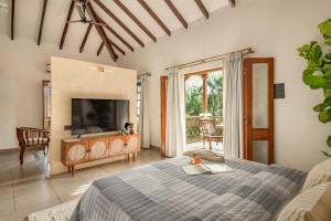 a bedroom with a bed and a television in a room at Sanctuary by RÊVE in Siolim