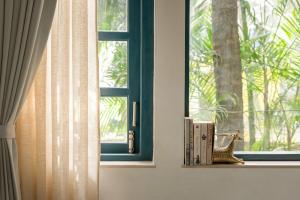 a window with books on a shelf in a room at Sanctuary by RÊVE in Siolim