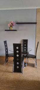 a dining room table and chairs with a vase of flowers at Bouleigh in Kempton Park +4 photos