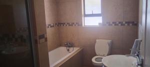 a bathroom with a toilet and a sink and a tub at Bouleigh in Kempton Park