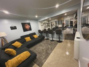 a living room with a couch and a barber shop at Cacém Maison in Cacém