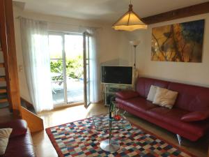 a living room with a red couch and a tv at Abc Ferienwohnungen Im Winter in Meersburg