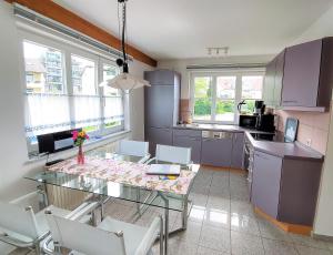 a kitchen with a glass table and white chairs at Abc Ferienwohnungen Im Winter in Meersburg