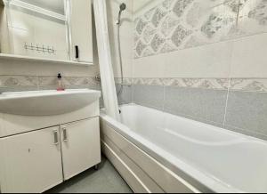 a white bathroom with a sink and a bath tub at Buiucani in Chişinău