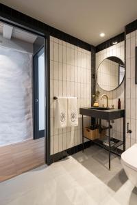 ein Badezimmer mit Waschbecken, Toilette und Spiegel in der Unterkunft ART Boutique in A Coruña