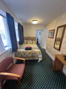 a hotel room with two beds and a chair at Near Hylands hotel family room in Nottingham