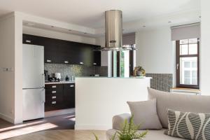 a kitchen with black cabinets and a white refrigerator at Sopot Haffnera Apartament z parkingiem - plaża - Centrum by Lion Apartments in Sopot +7 photos