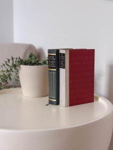 two books sitting on a table next to a plant at Charmantes Apartment in perfekter Lage mit kostenlosem Parken in Celle