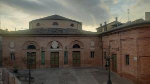 a large brick building with a clock on it at Il Palco Centrale in Tolentino