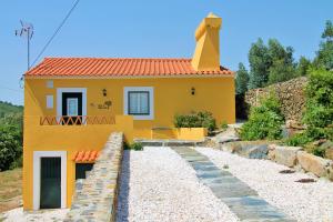 una piccola casa gialla su una strada sterrata di Quinta da Figueirinha a Marvão