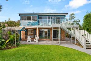 ein Haus mit einer Glasfassade in der Unterkunft 4 Bedroom Pet Friendly Home - 150m to Culburra Beach in Culburra Beach