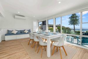 ein weißes Esszimmer mit Tisch und Stühlen in der Unterkunft 4 Bedroom Pet Friendly Home - 150m to Culburra Beach in Culburra Beach