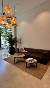 a living room with a brown couch and two tables at Prime Location in Laureles with AC & View in Medellín