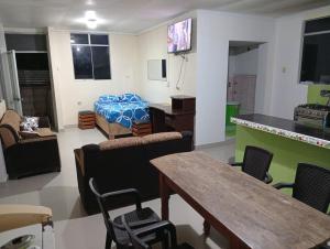 a living room with a table and chairs and a bed at Airbn b Estancia ALVARADO in Tingo María