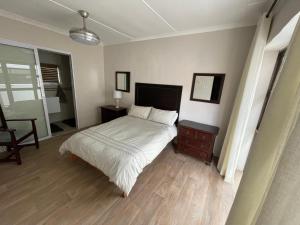 Un dormitorio con una cama, una mesa y una silla. en Klipwerf, en Struisbaai