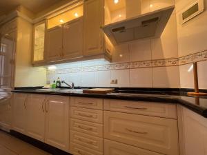 a kitchen with white cabinets and a sink at Viva Tenerife in Costa Del Silencio +14 photos