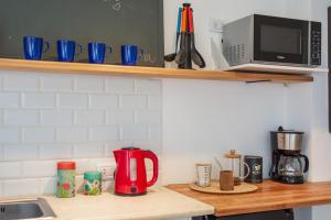 a kitchen counter with a microwave and some blue cups at Escapada ideal a Mar del Plata luz, diseño y ubicación perfecta in Mar del Plata