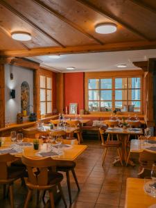 a restaurant with wooden tables and chairs and windows at ristorante con stanze Airolo in Airolo +12 photos