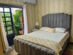 une chambre avec un grand lit et une fenêtre dans l'établissement Colonial leyton apartment, à Sans Souci