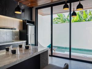 a kitchen with a counter with a view of the ocean at LM Home 2 Mendira in Candidasa +21 photos