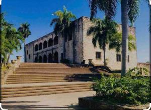 un bâtiment avec des palmiers devant dans l'établissement Colonial leyton apartment, à Sans Souci
