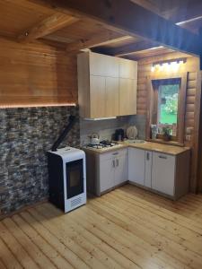 a kitchen with a stove and a microwave at Domek w Górach Prywatna Sauna i Balia in Klikuszowa