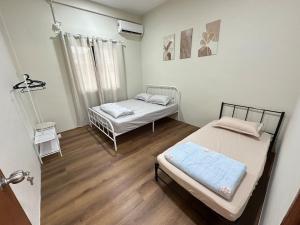 a small room with two beds in it at Permaisuri homestay in Bintulu