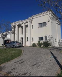un coche aparcado delante de un edificio blanco en MC Ceibos, en Belén de Escobar