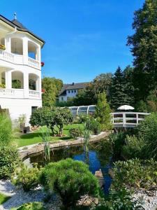 a garden with a pond in front of a building at Pension Weißer Hirsch in Schwarzenberg (Erzgebirge) +27 photos