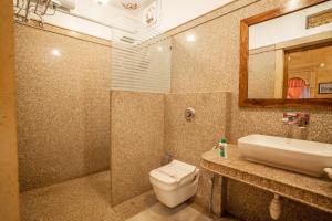 a bathroom with a toilet and a sink and a mirror at Garh Adhiraj A Luxurious Boutique Haveli in Jaisalmer