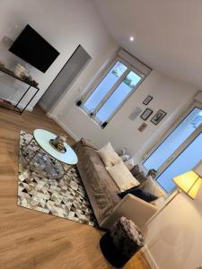 een woonkamer met een bank en een tafel bij "LE NID de SKYLAR" centre ville in Reims