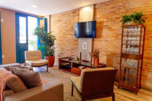 a living room with a couch and a tv on a brick wall at Vila de Cunha in Cunha +31 photos