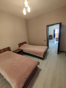a room with two beds and a hallway with a mirror at Moy goust house in Qusar