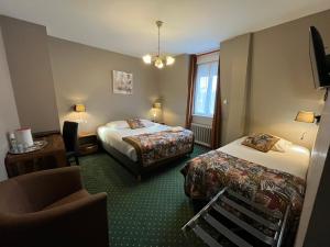 a hotel room with two beds and a chair at Hôtel & Appartements Le Florence in Saint-Quentin +83 photos