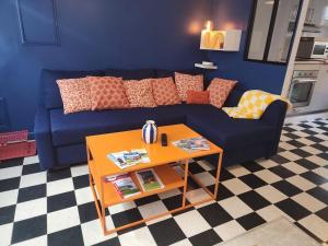 a living room with a blue couch and a table at La Fécampette in Fécamp +31 photos