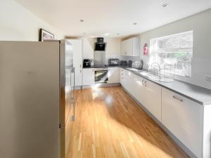 Una cocina con electrodomésticos blancos y suelo de madera. en Heather - Uk50104, en Brigg