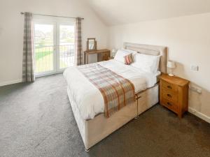 Un dormitorio con una cama grande y una ventana. en Heather - Uk50104, en Brigg
