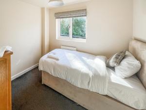Un dormitorio con una cama con sábanas blancas y una ventana. en Heather - Uk50104, en Brigg 4 fotos más