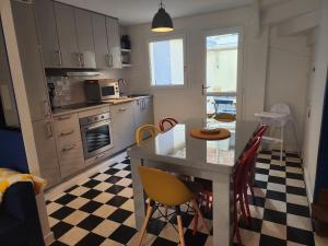 een keuken met een aanrecht en een tafel met stoelen bij La Fécampette in Fécamp +31 foto's