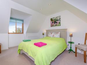 a bedroom with a green bed and a window at East Cottage in Croy +17 photos