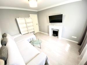 ein Wohnzimmer mit einer weißen Couch und einem Kamin in der Unterkunft Best location! Park, Casino, Theatre! in Wiesbaden