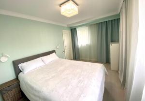 ein Schlafzimmer mit einem weißen Bett und einem Kronleuchter in der Unterkunft Best location! Park, Casino, Theatre! in Wiesbaden + 2 Fotos