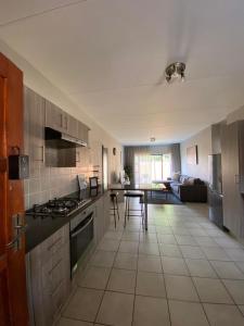 a kitchen with a stove and a table in a room at Yanaz Place in Germiston +1 photo